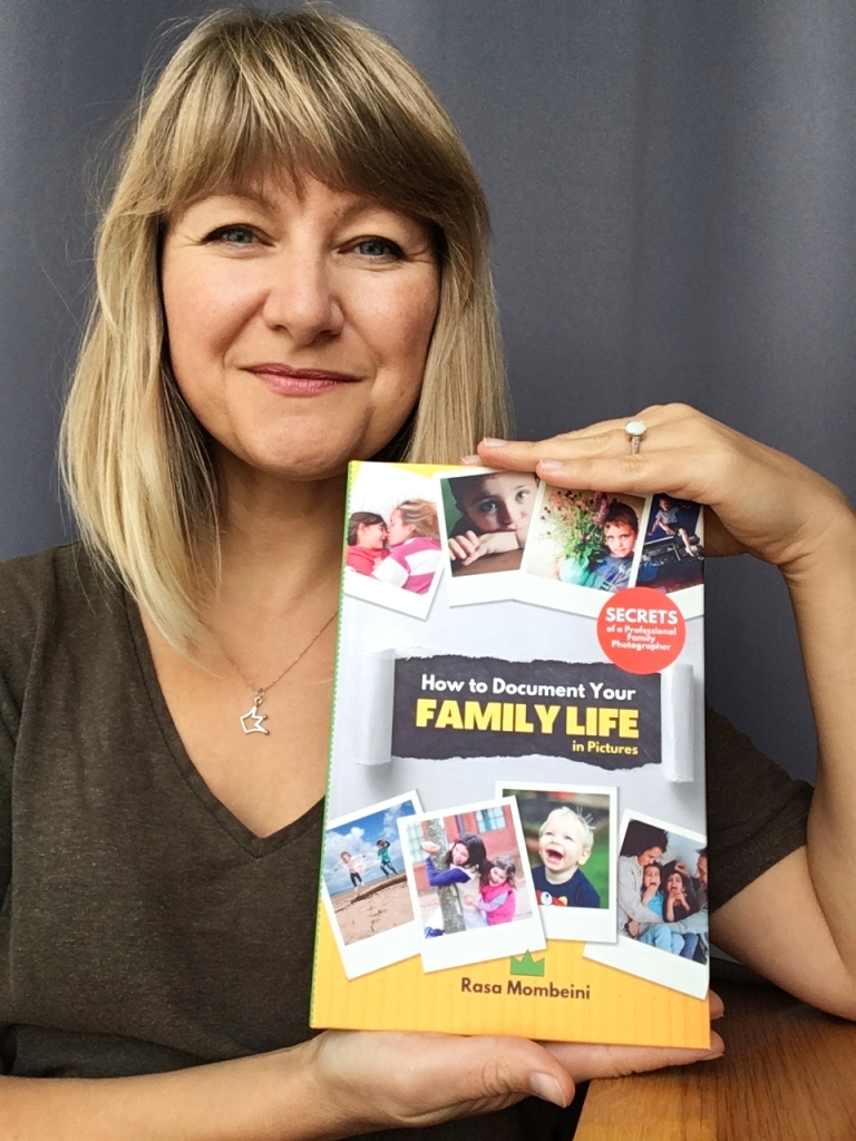 Rasa Mombeini holding a book How to Document Your Family Life in Pictures
